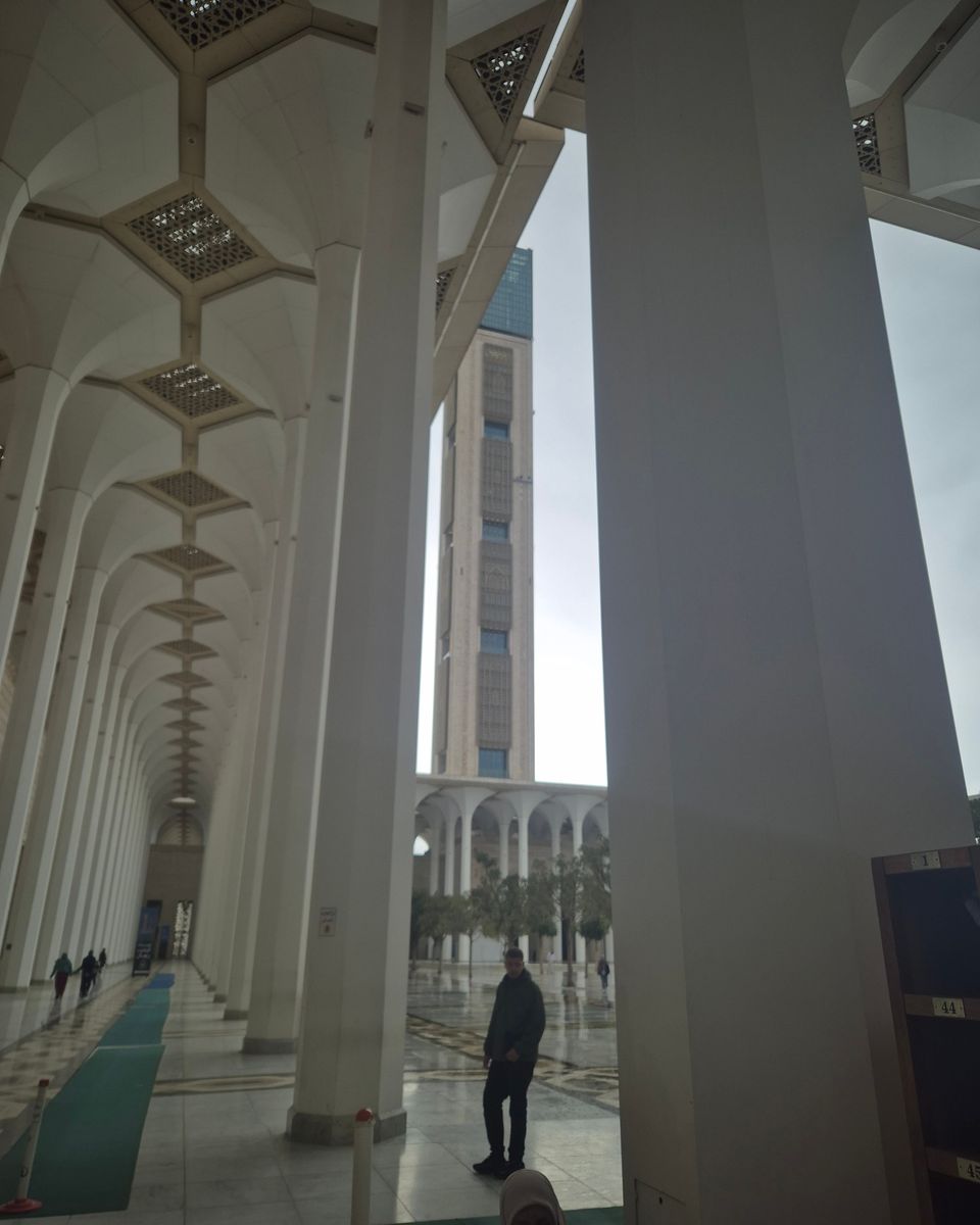 La galerie blanche à arcades de la Grande Mosquée d'Alger, avec son très haut minaret en arrière-plan