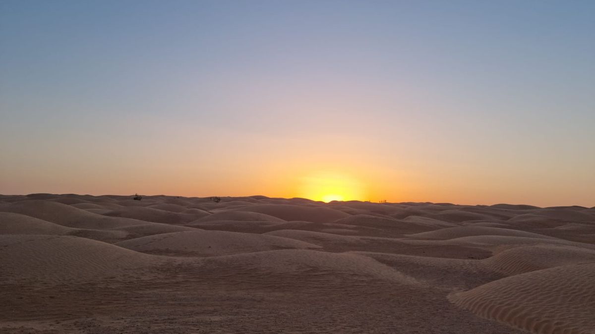 Coucher de soleil sur les dunes du Sahara tunisien, le soleil posé sur l'horizon