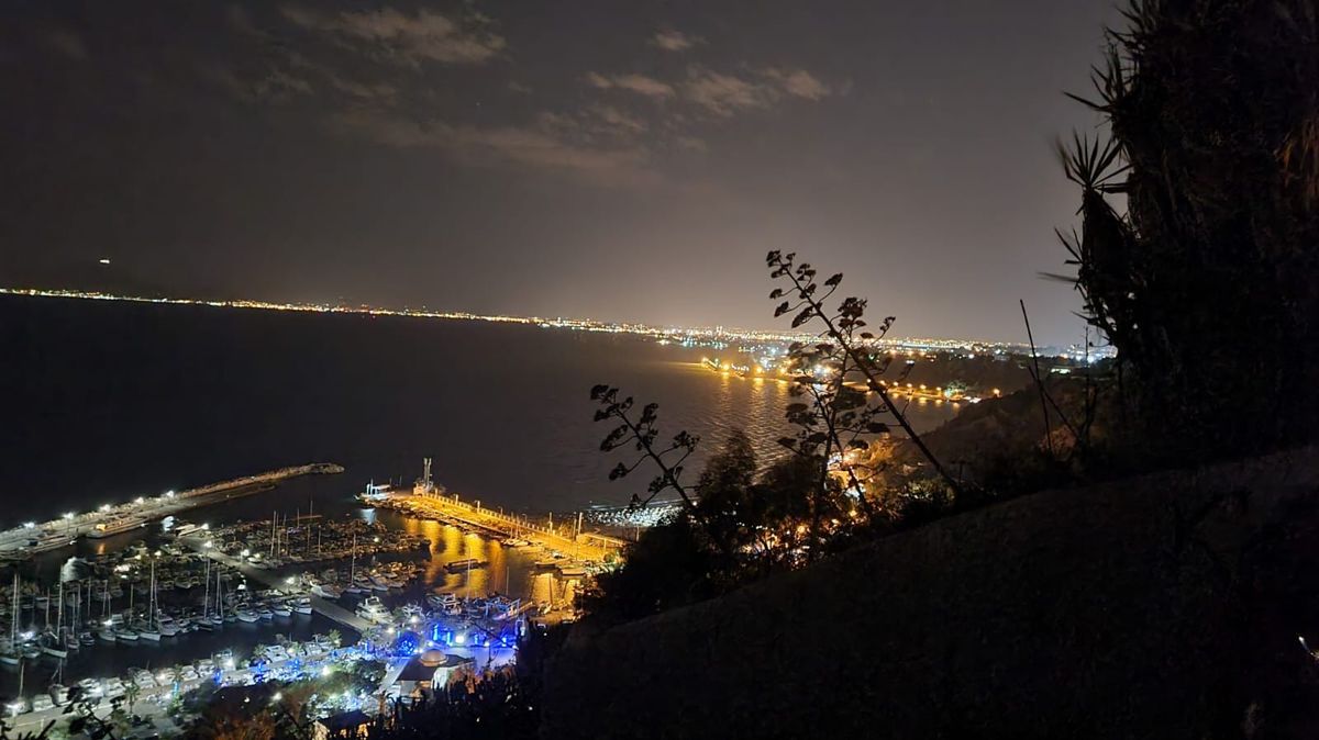 Vue de nuit depuis les hauteurs de Sidi Bou Saïd sur le port de plaisance illuminé et la côte